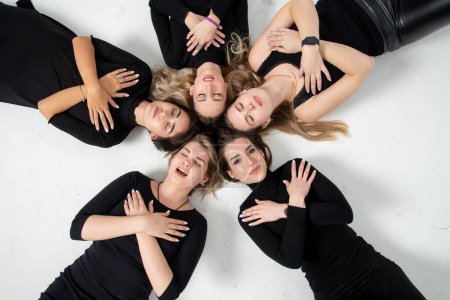 Photo for Group of young women lying in a circle, laughing, hugging, having fun, hands - Royalty Free Image