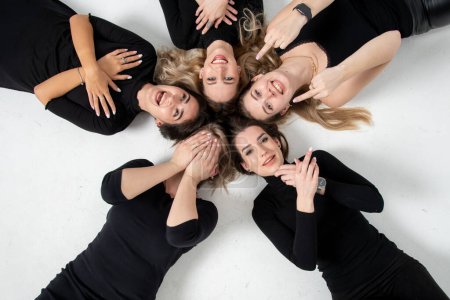 Téléchargez les photos : Group of young women lying in a circle, laughing, hugging, having fun, hands - en image libre de droit