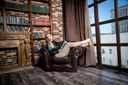 Téléchargez les photos : Beautiful girl with book sitting in chair - en image libre de droit