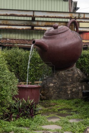 Photo for Giant teapot pouring tea into a large teacup in Pinglin, Taipei, Taiwan. - Royalty Free Image