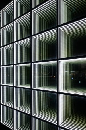 Foto de Imagen abstracta de patrones simétricos de luz verde y blanca en una fachada de edificios por la noche - Imagen libre de derechos