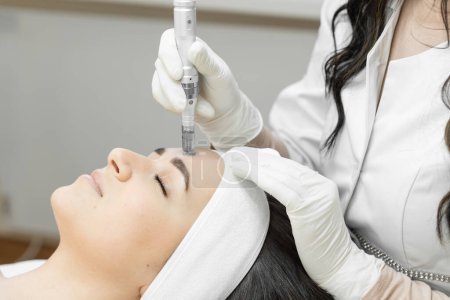 Mésothérapie fractionnée comme une méthode innovante de traitement de la peau du visage, qui assure son rajeunissement et sa récupération, qui est effectuée par un cosmétologue professionnel dans une clinique de beauté. Haut