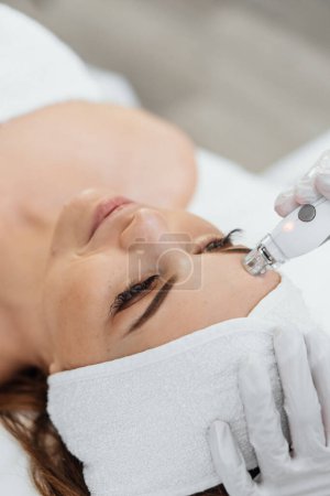 Photo for The woman receives a massage, promoting an overall sense of relaxation and physical health. A professional esthetician uses RF Lifting to stimulate collagen and maintain youthful skin. High quality - Royalty Free Image