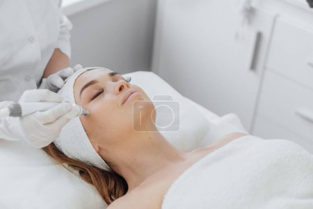 Die Kosmetikerin verwendet RF-Lifting, um den Hautton zu verbessern und die Gesichtskontur zu straffen. Diese sichere und effektive Methode nutzt hochfrequente Wellen, um Kollagen und Elastin zu stimulieren und die Haut zu verbessern