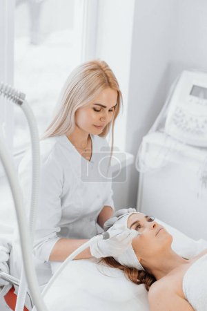 Ein Kosmetologe, ein echter Profi, verwendet Vakuum und HF-Lifting, um dem Kunden effektive und sichere Verfahren zur Lösung der Probleme der Hautalterung zu bieten. Hochwertiges Foto