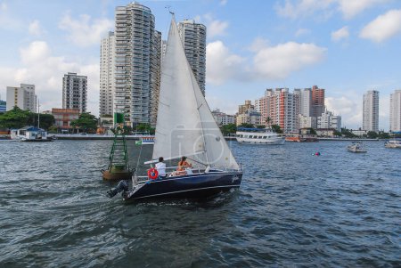 Photo for City of Santos, Brazil. February 19, 2011. Sailing boat in the Port of Santos channel. In the background, the waterfront buildings in the Ponta da Praia region. - Royalty Free Image