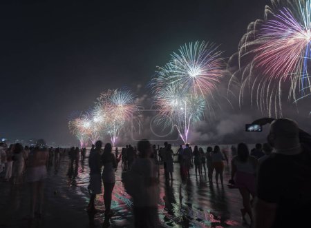 Foto de Fireworks on the beach. People watching watching the explosion of fireworks during the celebration of the new year. Santos city, Brazil. - Imagen libre de derechos
