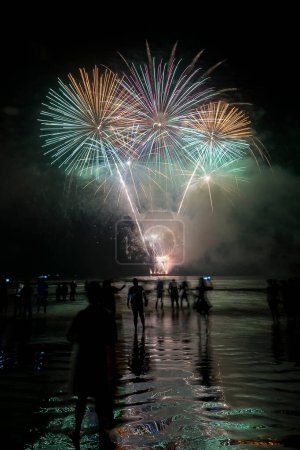 Foto de Fireworks on the beach. People watching the explosion of fireworks during the celebration of the new year. Santos City, Brazil. - Imagen libre de derechos