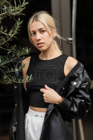 Photo for Blonde woman in leather shirt jacket and tank top standing on street in Miami - Royalty Free Image