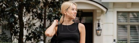 Téléchargez les photos : Femme blonde regardant loin tout en se tenant près de la maison à Miami, bannière - en image libre de droit