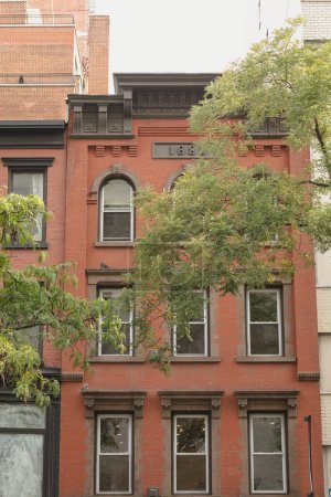 Foto de Old house with 1888 year on facade near trees in Brooklyn Heights district of New York City - Imagen libre de derechos