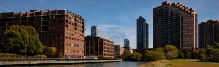 Téléchargez les photos : New York City buildings near green lawn and river, banner - en image libre de droit