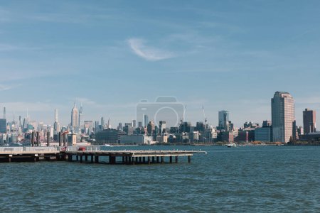 malerischer Blick auf die Bucht von New York mit Pier und Wolkenkratzern von Manhattan