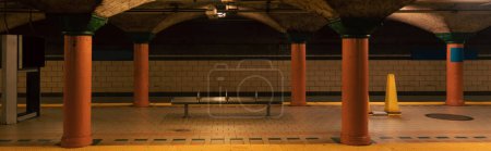 estación de metro con columnas y suelo de baldosas en la ciudad de Nueva York, pancarta