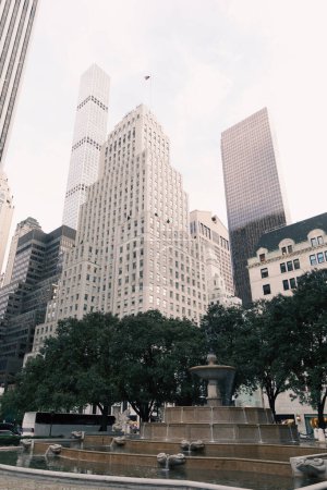 Téléchargez les photos : Arbres et fontaine près de Rockefeller Center au centre de Manhattan à New York - en image libre de droit