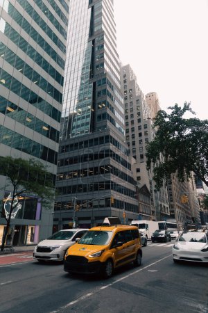 Photo for NEW YORK, USA - OCTOBER 13, 2022: yellow taxi car in traffic on road in midtown of city - Royalty Free Image