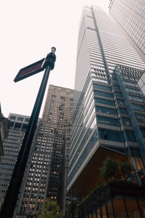 Blick auf einen Straßenmast mit Zeiger in der Nähe von Wolkenkratzern in Midtown Manhattan in New York City