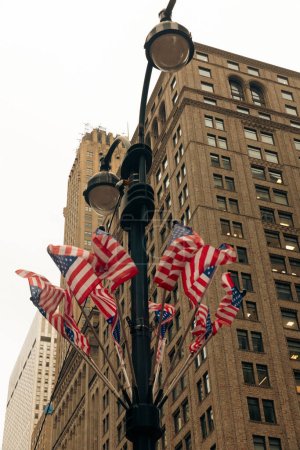 Téléchargez les photos : Vue à angle bas des drapeaux des Etats-Unis sur la lanterne de rue à New York - en image libre de droit