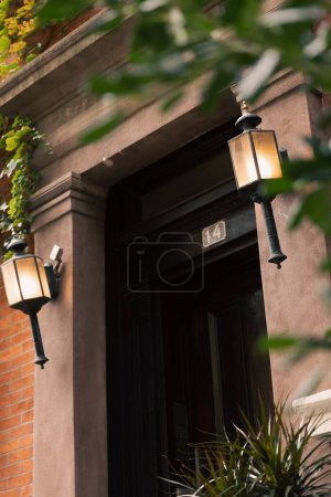 stone house with black door and lanterns on blurred foreground in New York City
