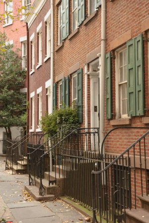 Photo for Brick dwelling house with metal railings near entrances on street of New York City - Royalty Free Image