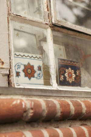 vieja ventana y azulejos con patrón floral en Brooklyn Heights distrito de Nueva York