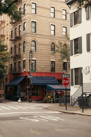 budynek z kawiarnią w pobliżu skrzyżowania i znaków drogowych na ulicy miejskiej w Nowym Jorku