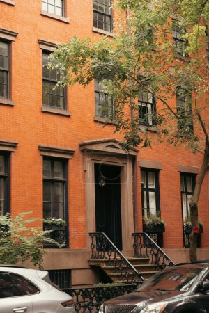 Rotes Backsteingebäude in der Nähe von Autos und Bäumen im New Yorker Stadtteil Brooklyn Heights
