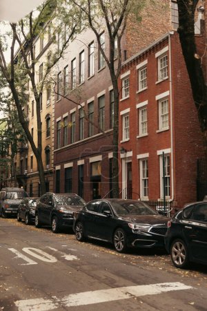 Coches y casas de ladrillo en la calle en la ciudad de Nueva York