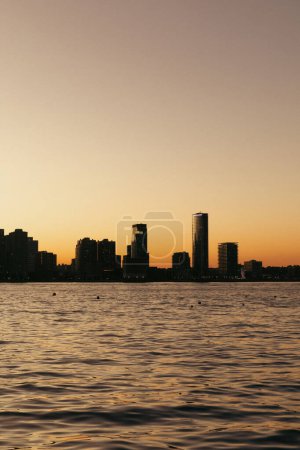 Hudson river and buildings on riverbank during sunset in New York City
