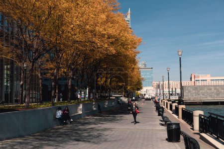 Téléchargez les photos : NEW YORK, USA - OCTOBER 11, 2022: Autumn trees on Hudson river waterfront walkway at daytime - en image libre de droit