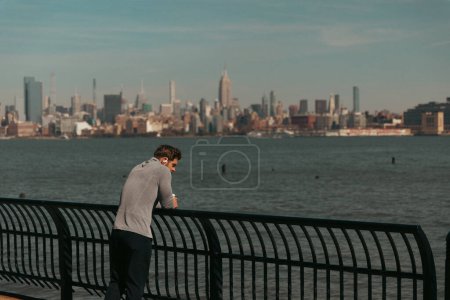 Foto de NEW YORK, USA - OCTOBER 11, 2022: Man standing on Hudson river waterfront walkway at daytime - Imagen libre de derechos
