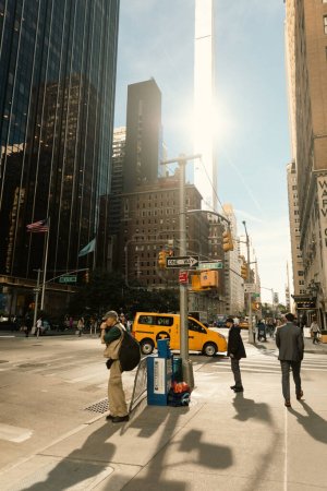 Photo for NEW YORK, USA - OCTOBER 11, 2022: People on sidewalk near road on urban street in Manhattan - Royalty Free Image