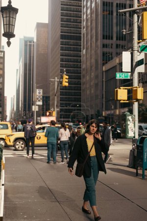 NEW YORK, USA - PAŹDZIERNIK 11, 2022: Kobieta spacerująca po zamglonej miejskiej ulicy na Manhattanie 