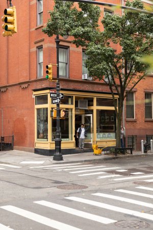 Téléchargez les photos : NEW YORK, USA - OCTOBER 11, 2022: Cafe on corner of building and tree on urban street in Manhattan - en image libre de droit