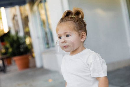 Porträt eines kleinen Mädchens mit grauen Augen, das auf der Straße in Miami wegschaut 