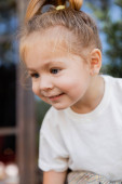 portrait of cheerful toddler girl in white t-shirt smiling and looking away  Poster #643494312