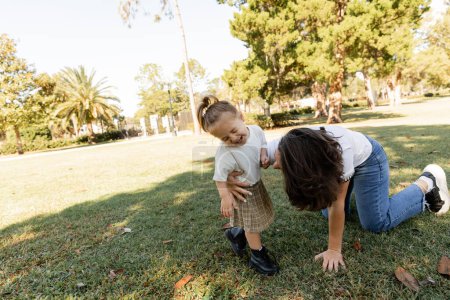 Kleinkind lacht Mutter beim gemeinsamen Spielen im Park von Miami an 