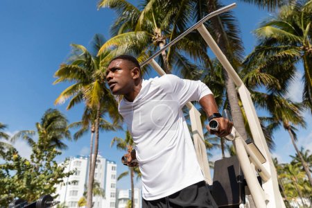 vue à faible angle du sportif afro-américain travaillant sur la plage de Miami 
