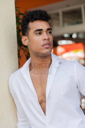 Foto de Retrato de un joven y guapo hombre cubano de camisa blanca mirando hacia Miami, playa sur - Imagen libre de derechos