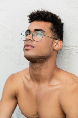 Photo for Portrait of shirtless muscular young cuban man with curly hair and stylish round-shaped eyeglasses - Royalty Free Image