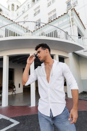 Entspannter Kubaner in weißem Hemd und Jeans mit stylischer Rundbrille in Miami