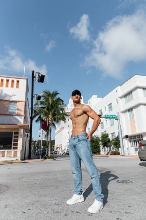 sexy gut aussehender kubanischer Mann mit athletischem Körper in Baseballkappe auf der urbanen Straße in Miami, Sommer 
