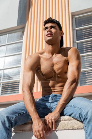Portrait of confident and sexy young cuban man with athletic body on  street in Miami, south beach