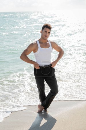 handsome and muscular Cuban man standing in ocean water in Miami South Beach, Florida