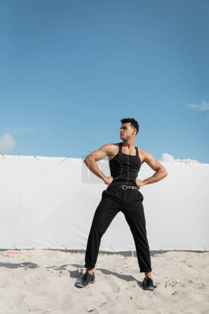 Téléchargez les photos : Jeune homme cubain beau et musclé en tenue noire et élégante à Miami, plage du sud - en image libre de droit