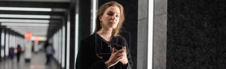 Téléchargez les photos : Jeune femme à la mode en veste noire posant dans un immeuble avec lampes fluorescentes à Berlin, bannière - en image libre de droit