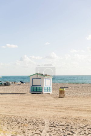 Téléchargez les photos : Une cabane de sauveteur se dresse sur une plage de sable près de l'océan, offrant protection et assistance aux amateurs de plage. - en image libre de droit