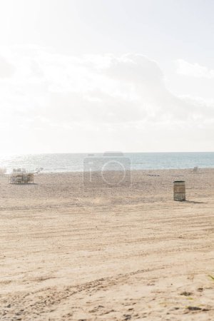 Téléchargez les photos : Trailer parked on a sandy beach, ready for a seaside harvest under a clear sky. - en image libre de droit