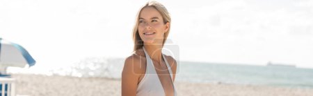 Foto de A young beautiful blonde woman stands on a Miami beach - Imagen libre de derechos
