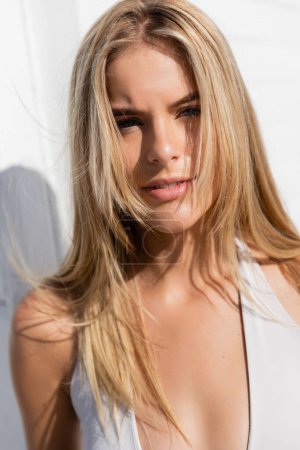 Téléchargez les photos : Une jeune, belle femme blonde pose gracieusement sur Miami Beach, ses cheveux longs coulant dans la brise. - en image libre de droit